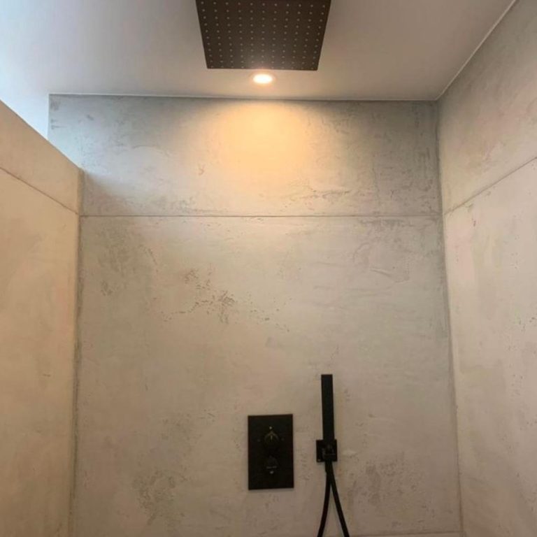 Minimalist Duschbereich mit grauen Wänden und Deckenstrahler.