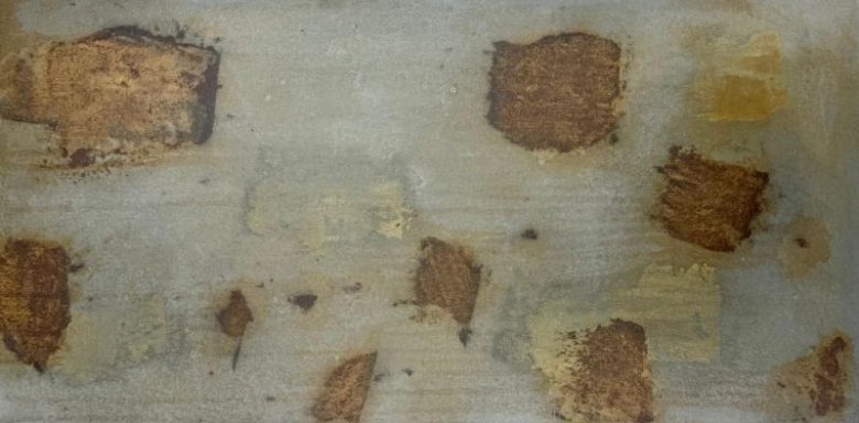 Texturierte Wand mit farbigen Flecken in Braun- und Beigetönen.
