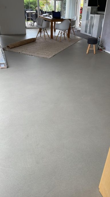 Heller Boden mit einem Tisch und einem Stuhl im Hintergrund.