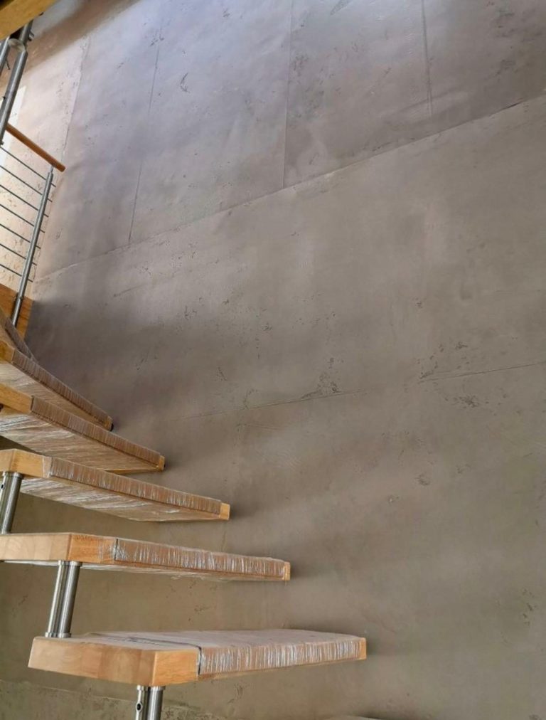 Bodenansicht mit glattem, grauem Beton und Holzgeländer.