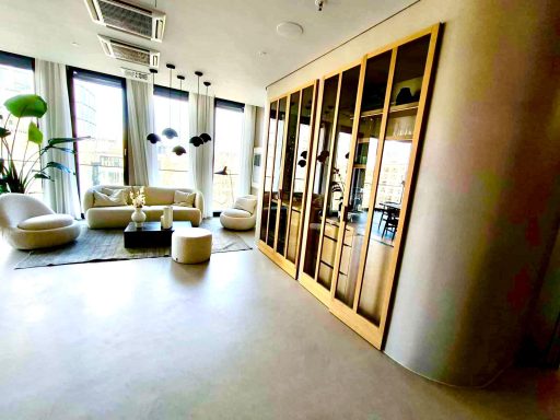 Moderne, helle Wohnlandschaft mit bequemen Möbeln und einem Glaskunstwerk.
